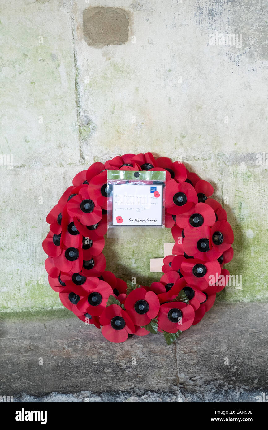 Couronne de pavot appuyé contre un mur en pierre avec British Legion remarque du souvenir Banque D'Images