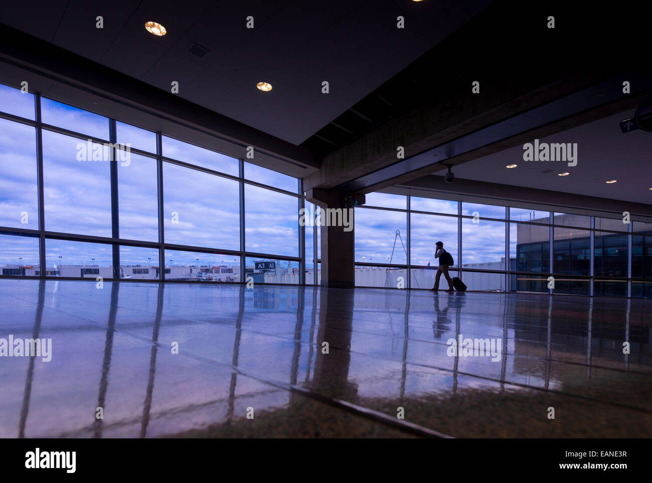 Man Walking & Talking On Cell Phone At Airport Banque D'Images