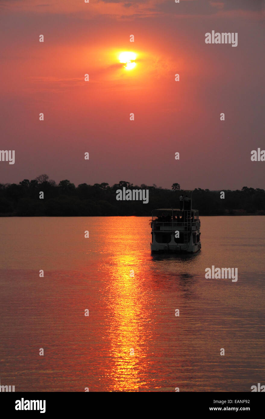 Un bateau de croisière de la rivière africaine silhouette sur le soleil couchant. Banque D'Images