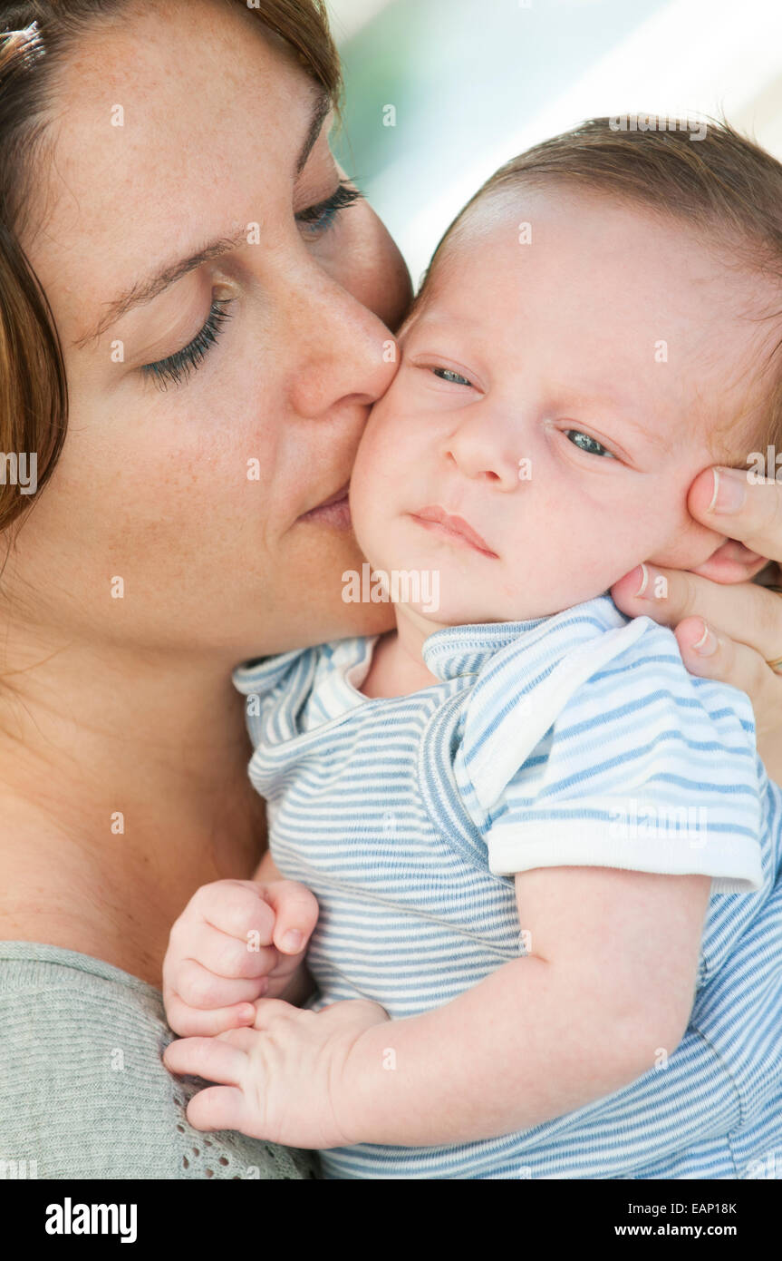 Mère embrassant son nouveau-né baby boy outdoors Banque D'Images