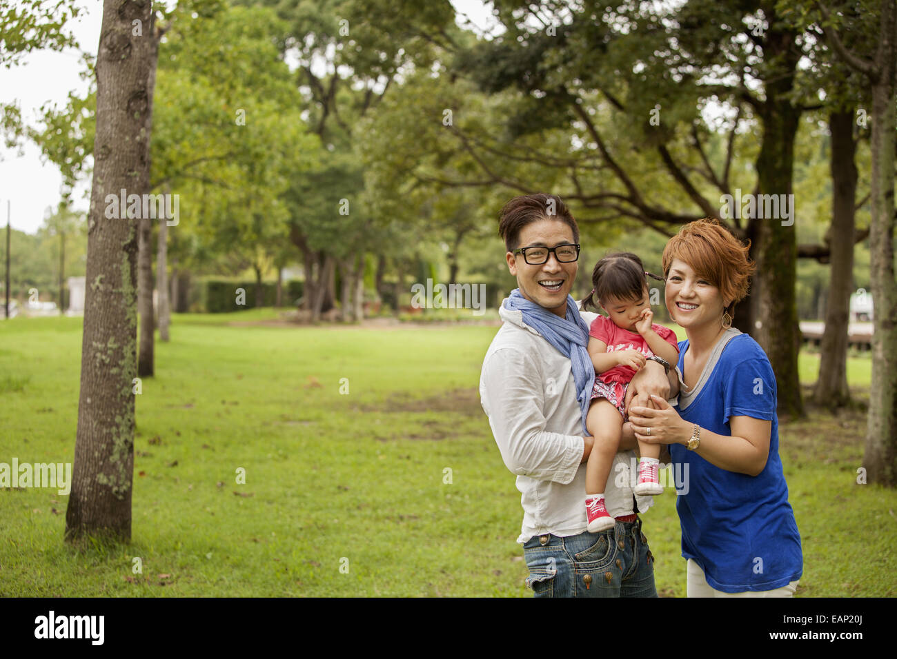 Famille dans un parc. Deux parents et un enfant. Banque D'Images