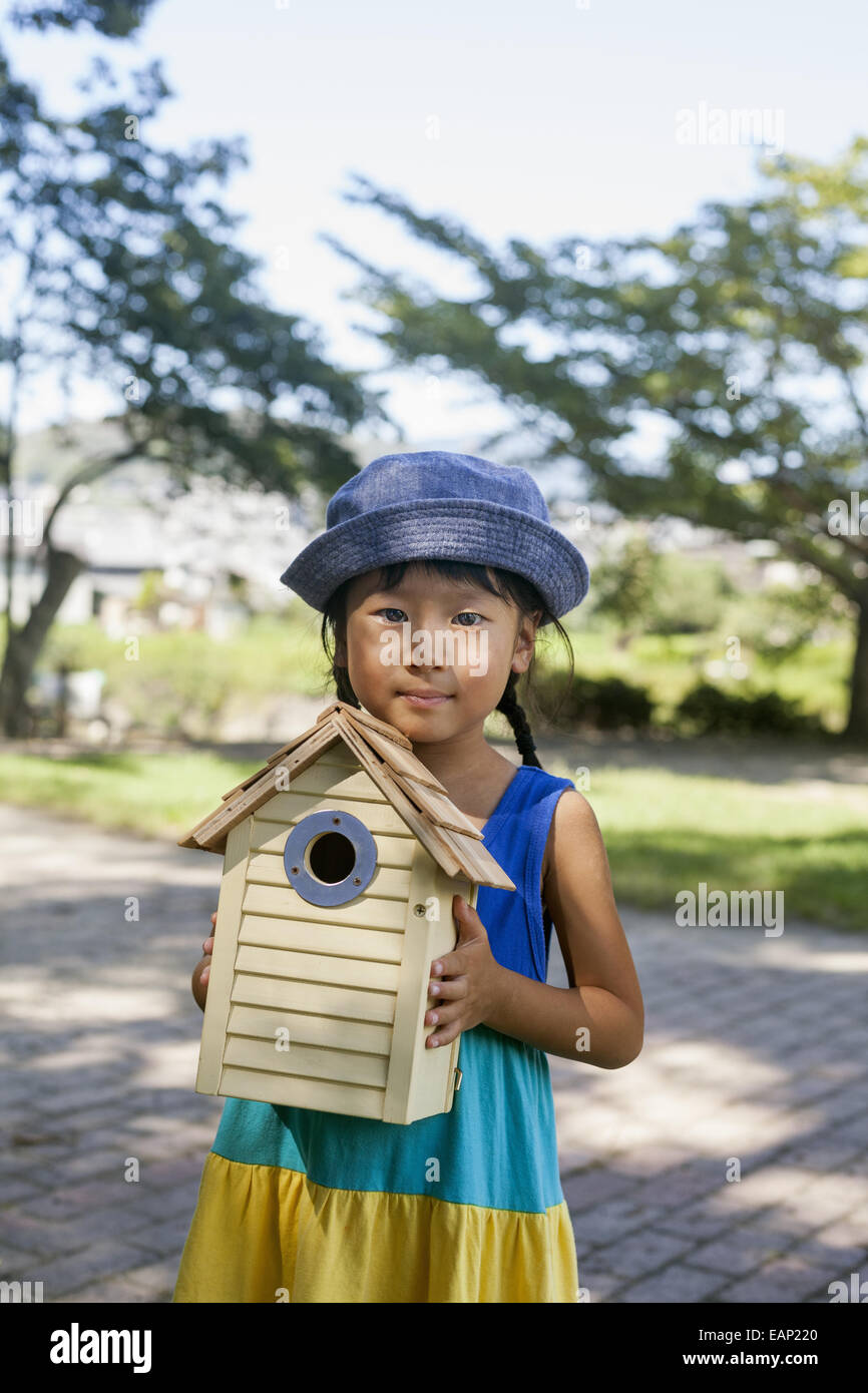 Jeune fille portant une robe d'été et chapeau de soleil, la tenue d'une  maison d'oiseau Photo Stock - Alamy