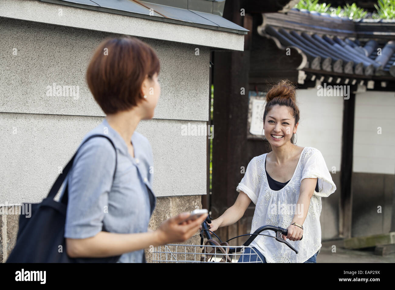 Le chat d'une femme à une autre femme assise sur un vélo. Banque D'Images