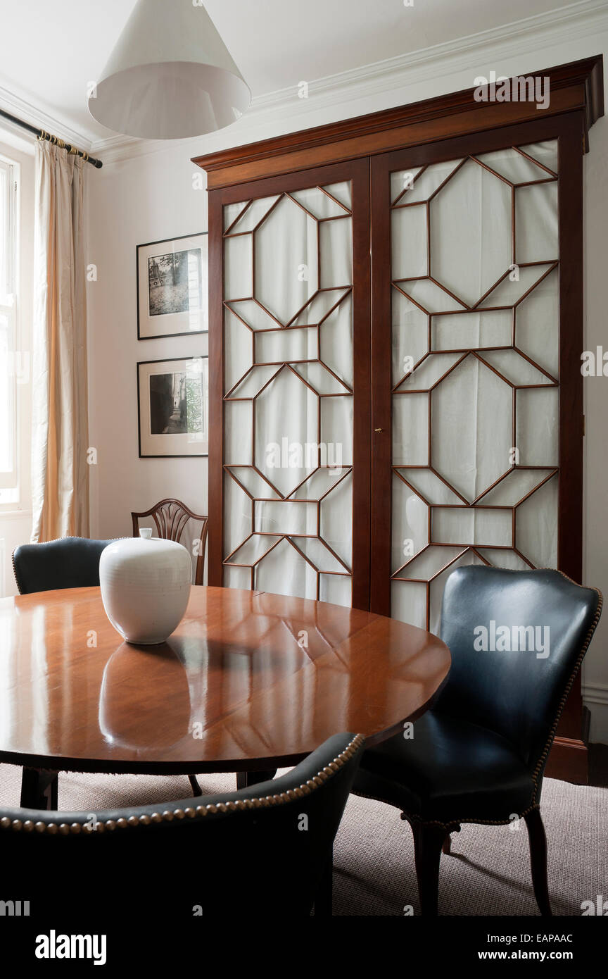 Table en bois et de fauteuils en cuir dans la salle à manger avec porte armoire en acajou Banque D'Images