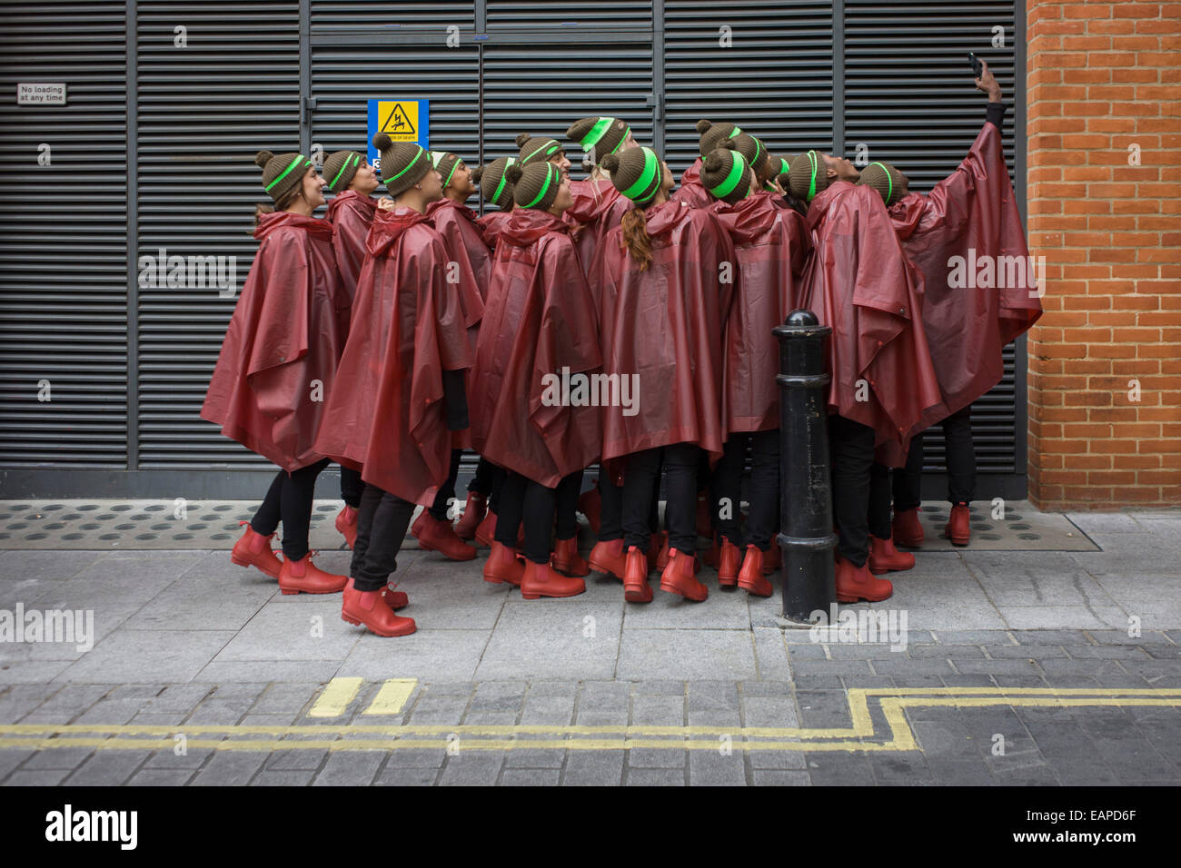 Londres, Royaume-Uni. 19 novembre, 2014. Prendre un des danseurs avant d'effectuer des selfies UK company Hunter effectuer une chorégraphie de danse pour lancer officiellement le nouveau magasin phare de la marque dans le quartier londonien de Regent Street. Vingt huit danseurs arrêté leur production avec les acheteurs de 'S' sous la pluie." Photo : Richard Baker / Alamy Live News. Banque D'Images