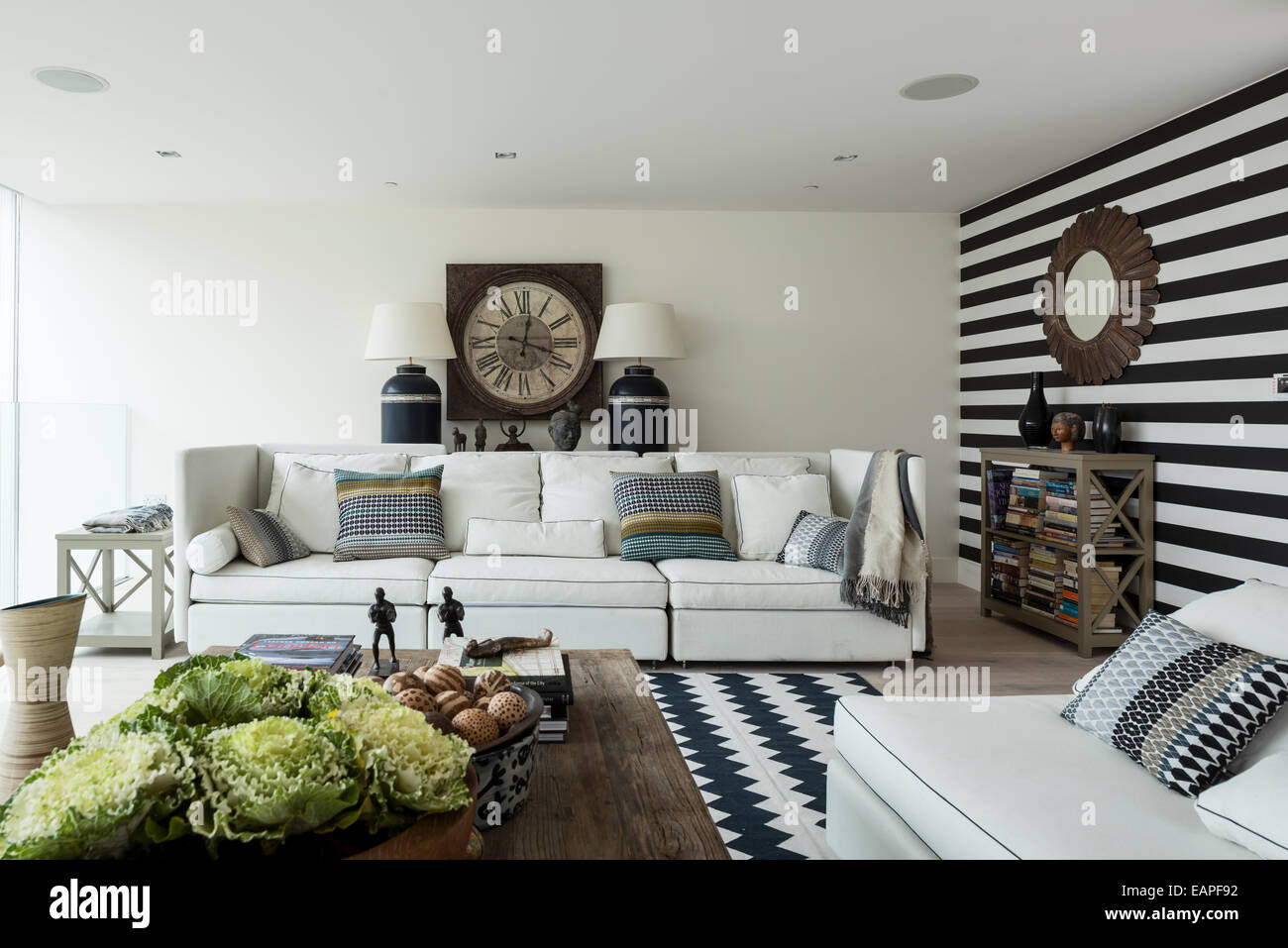 Mur rayé noir et blanc dans la salle de séjour avec chevron tapis à motifs. Le canapé est un 5-pièces de Brooklyn à Oka. Banque D'Images