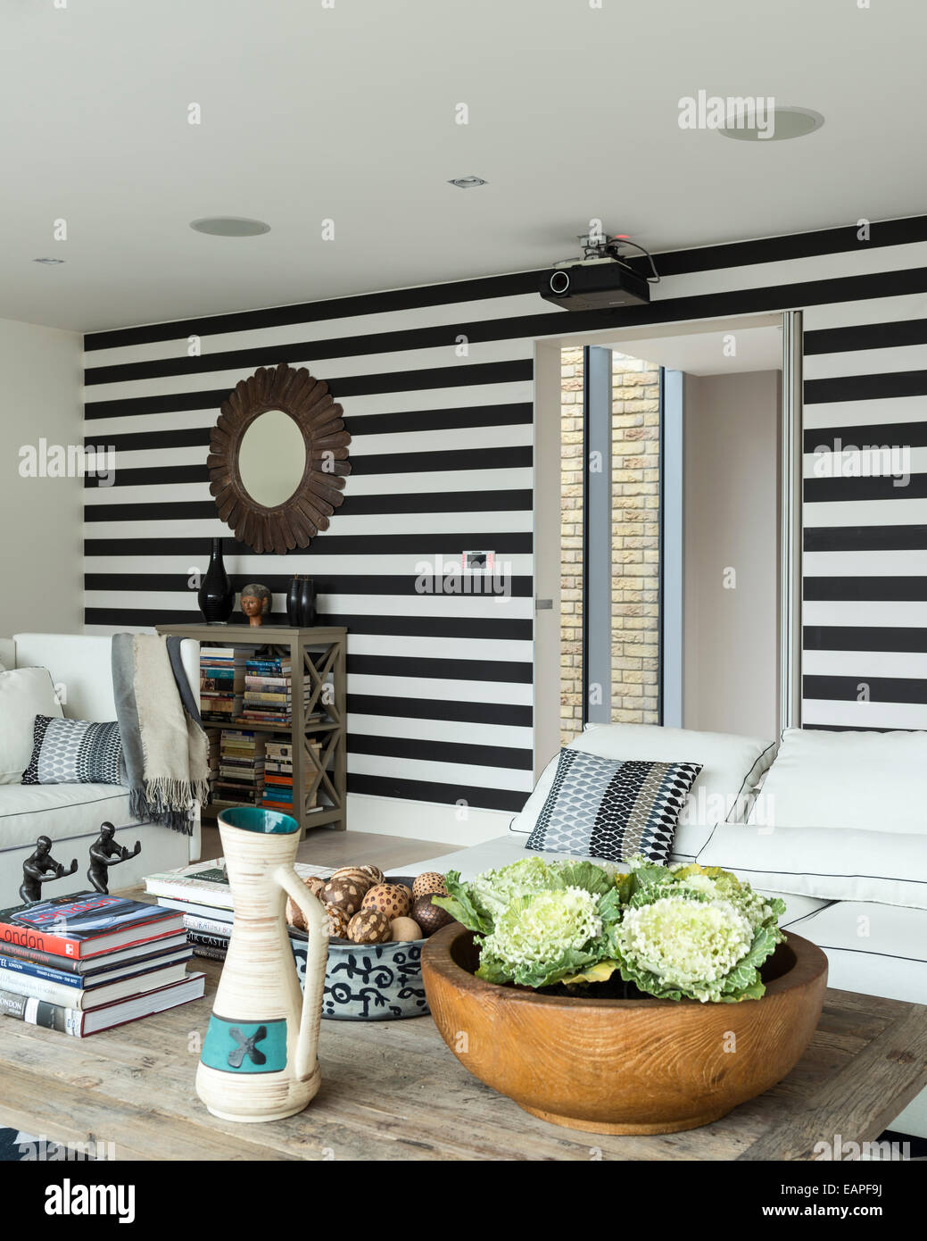 Mur rayé noir et blanc dans la salle de séjour avec chevron tapis à motifs. Banque D'Images