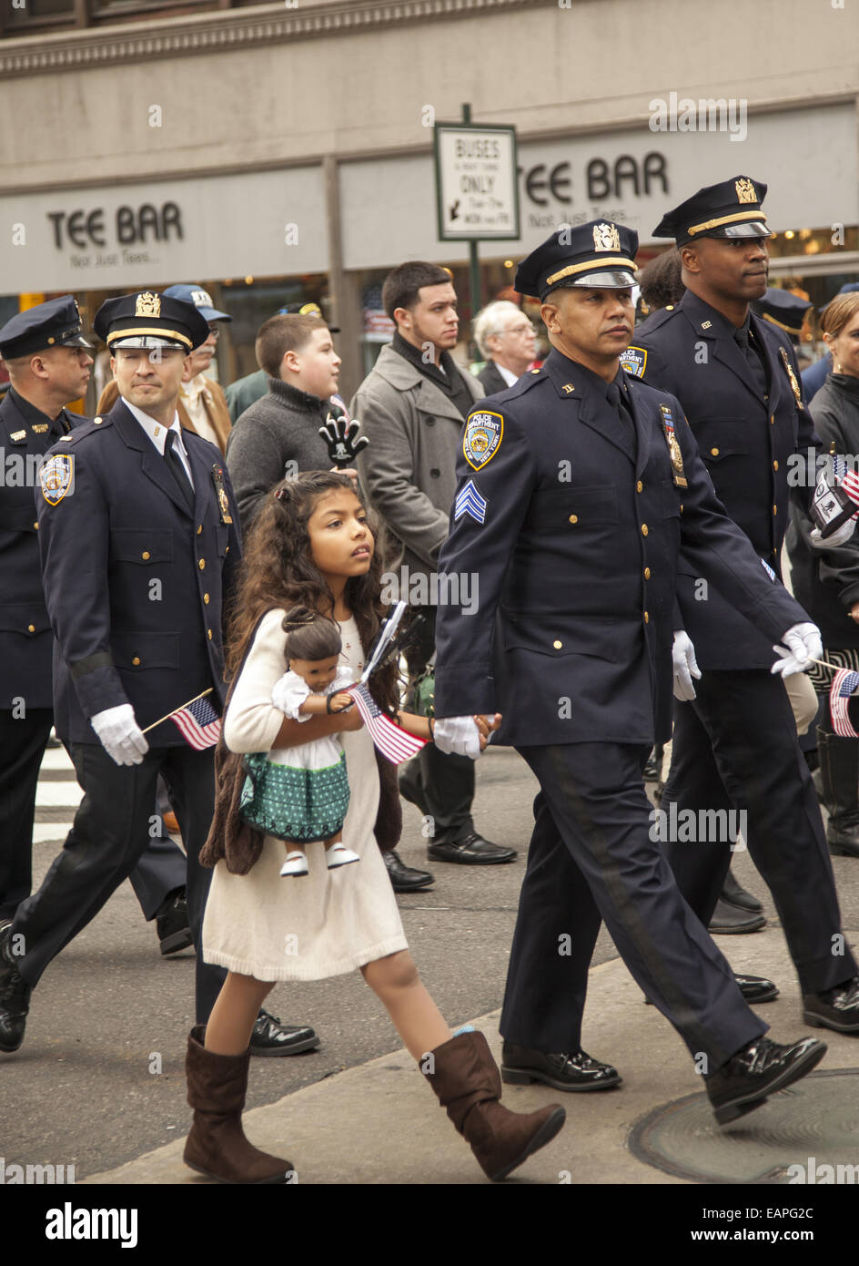 Défilé des anciens combattants, 5e Avenue, New York City. La police de New York avec marches Sargent sa jeune fille doll et d'un drapeau à la main. Banque D'Images