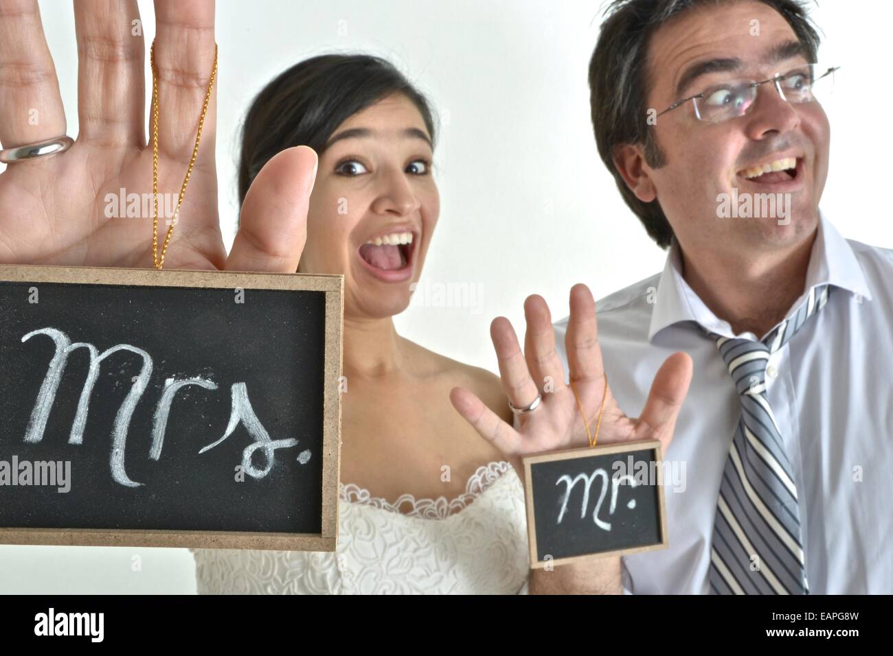 Nouvelle mariée hispanic couple holding signs disant ' Mr' et ' Mme' dans leurs mains. Banque D'Images