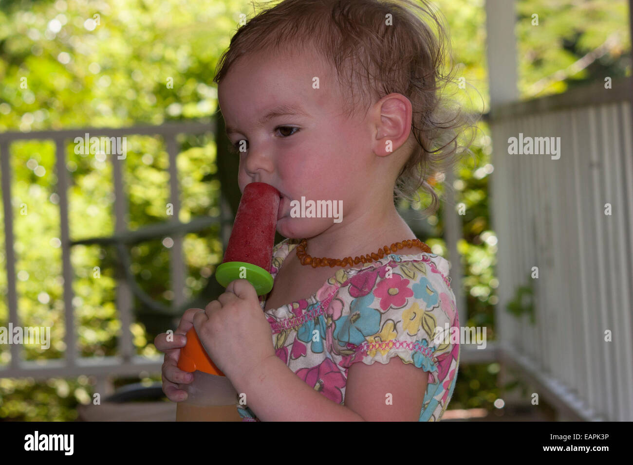 Bébé fille prend la première bouchée d'un popsicle maison Banque D'Images