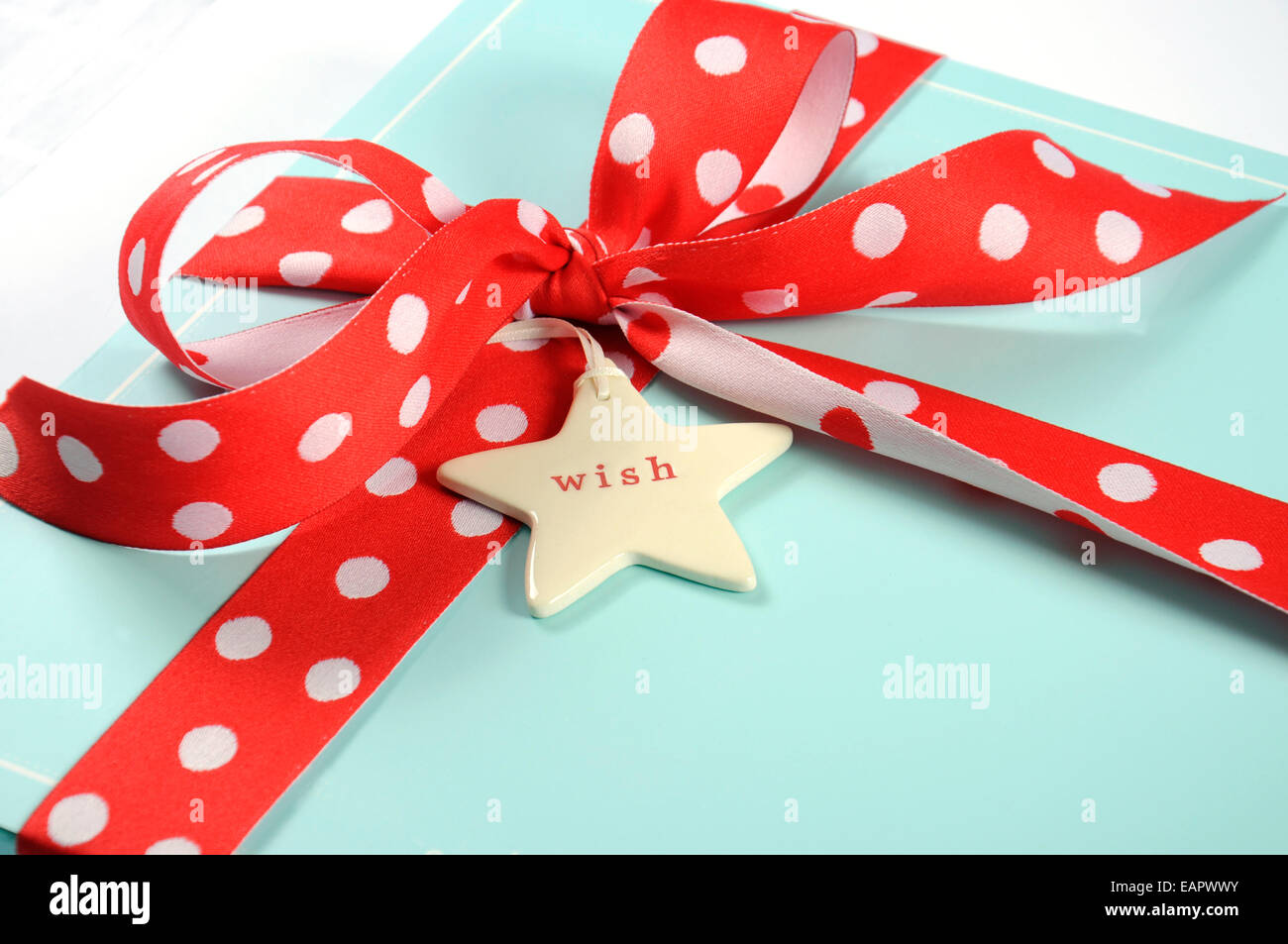 Bonnes fêtes de Noël festive aqua bleu pâle boîte-cadeau enveloppé de ruban rouge à pois, gros plan. Banque D'Images