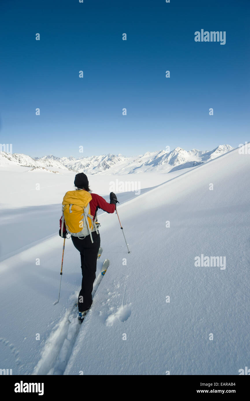 Femme skieur d'arrière-pays de l'écorcher à travers un névé sur Eagle Glacier, Chugach Mountains, Southcentral Alaska, Winter/N Banque D'Images