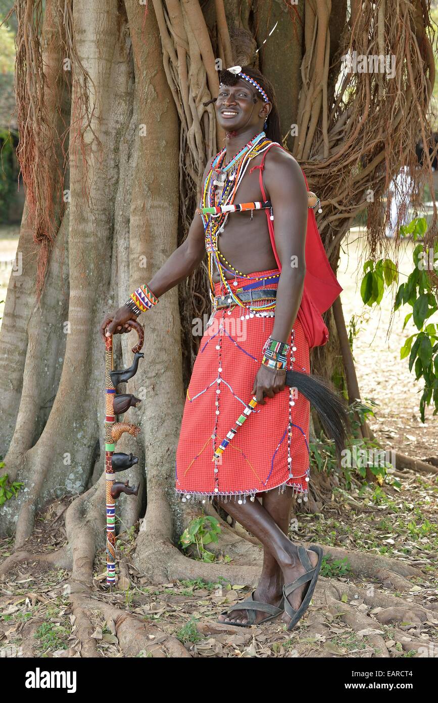 Guerrier massaï portant des vêtements traditionnels et debout dans une pose typique sur une jambe, près de Masai Mara, Enkutoto Banque D'Images