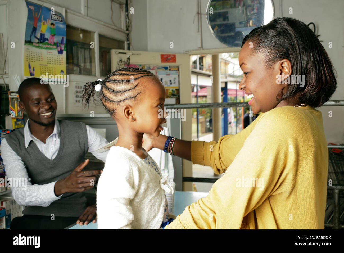 Une mère et sa fille pour payer l'épicerie du supermarché local de Nairobi, Kenya. Banque D'Images