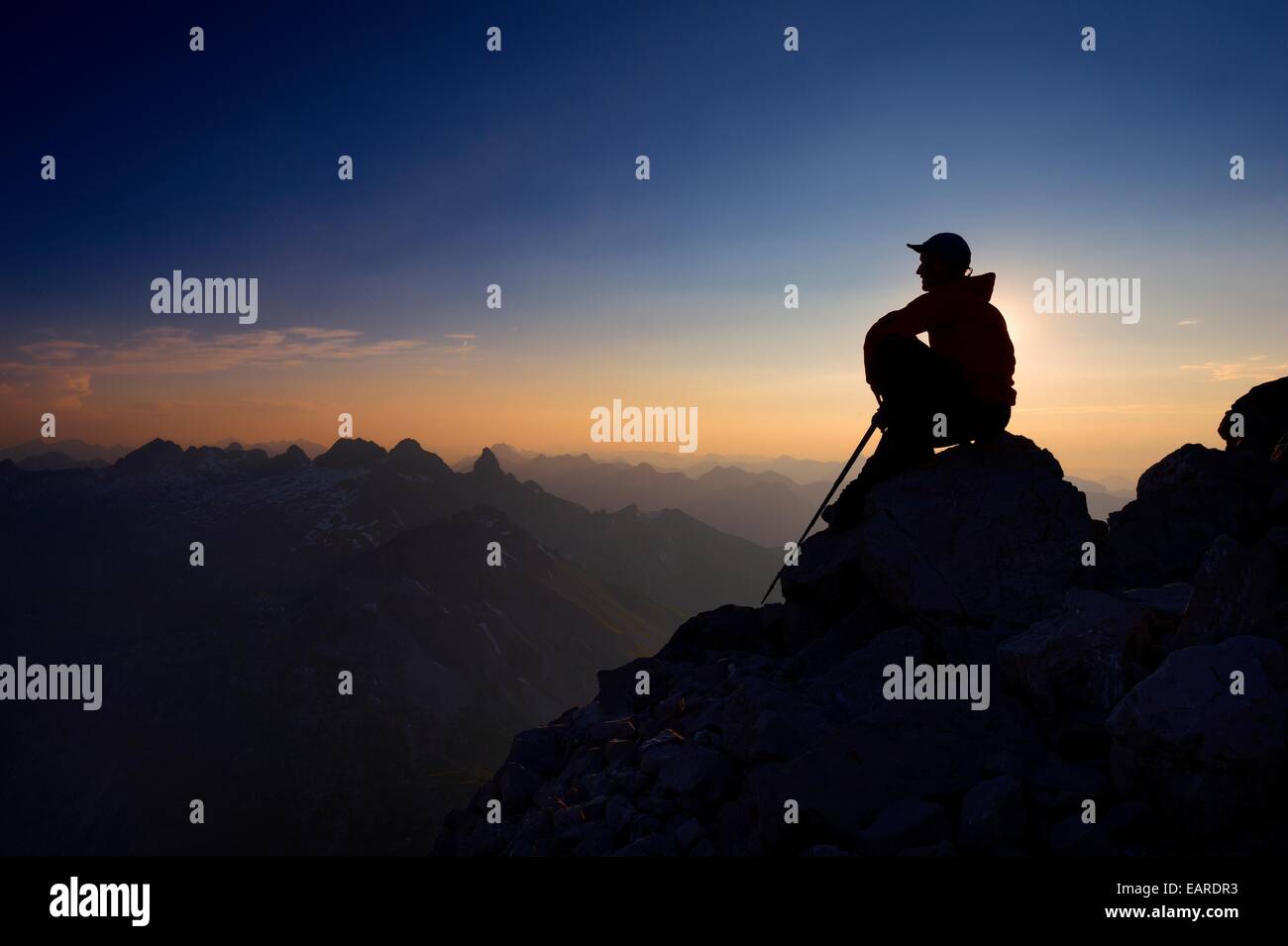 Mountaineer assis sur un rocher sur la montagne Großer Krottenkopf au crépuscule, Allgäuer Alpen, Tyrol, Autriche Banque D'Images