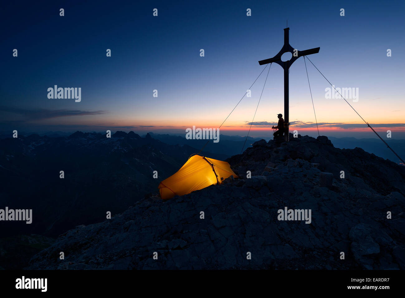 Mountaineer avec une tente au sommet, une croix sur la montagne Großer Krottenkopf au crépuscule, Allgäuer Alpen, Tyrol, Autriche Banque D'Images