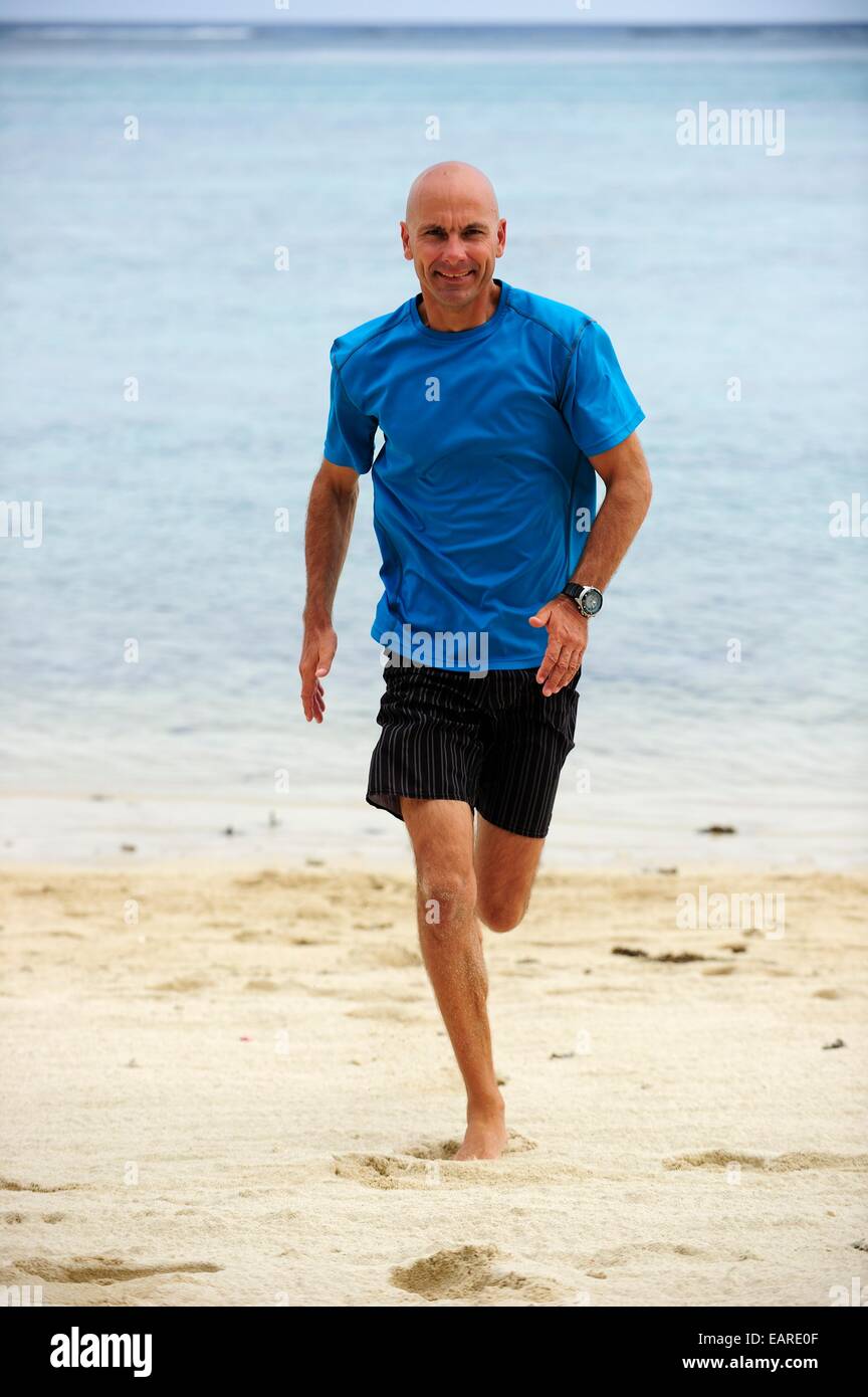 L'homme, début des années 40, le jogging le long d'une plage de sable fin, le morne, La Gaulette, Île Maurice Banque D'Images