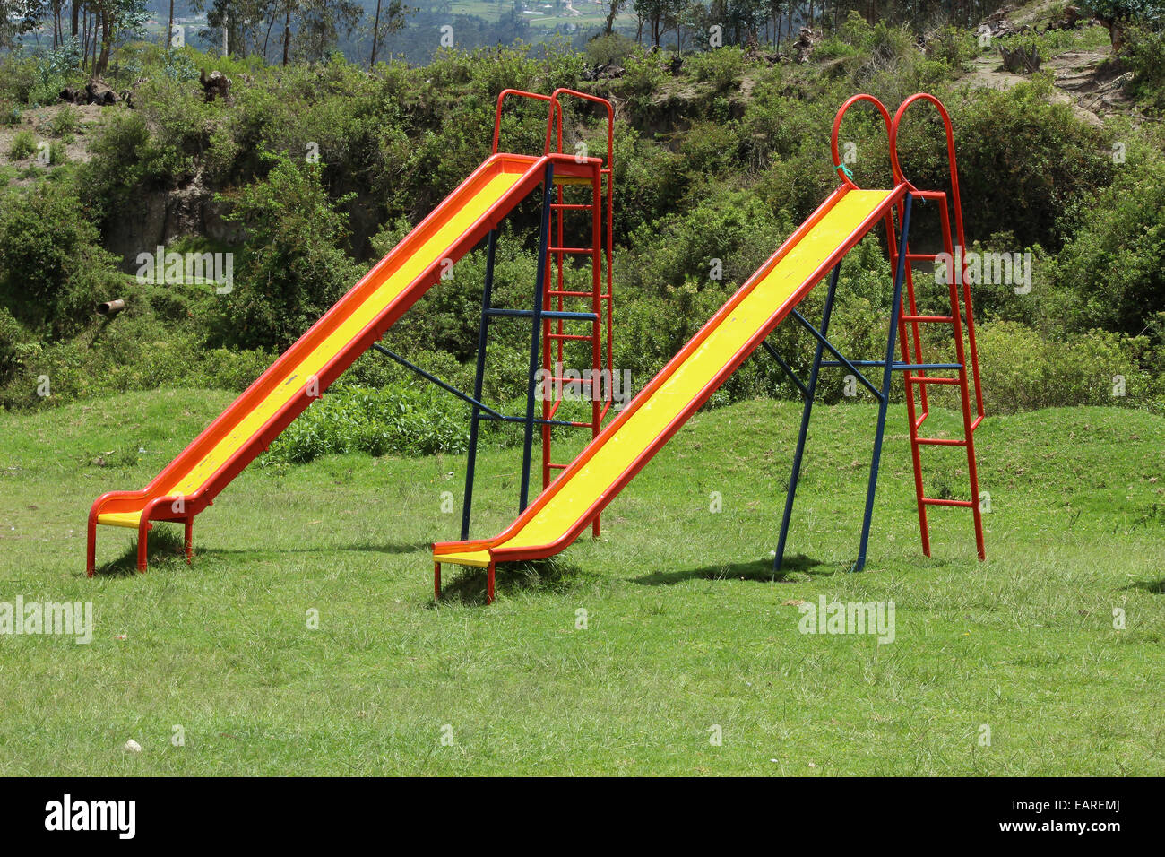 Métal coloré les diapositives dans une aire de jeux pour enfants à Cotacachi (Équateur) Banque D'Images