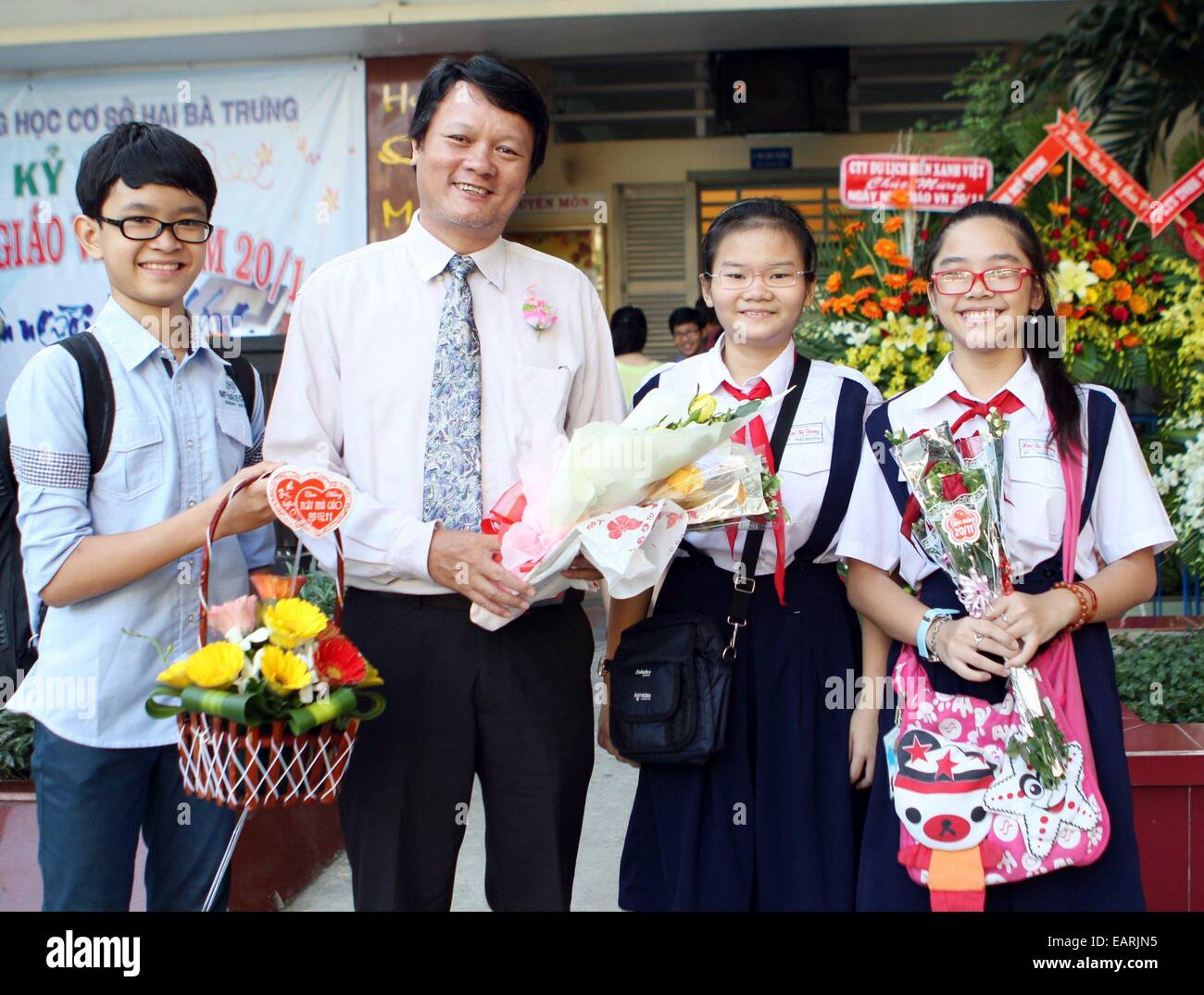 Ho Chi Minh Ville, Vietnam. 20 Nov, 2014. Les élèves posent pour des photos avec leur enseignant sur la journée de l'enseignant vietnamien à Ho Chi Minh Ville, Vietnam, 20 novembre 2014. Journée de l'enseignant vietnamien est une célébration annuelle tenue le 20 novembre ici. Le crédit : Nguyen Huyen/Xinhua/Alamy Live News Banque D'Images