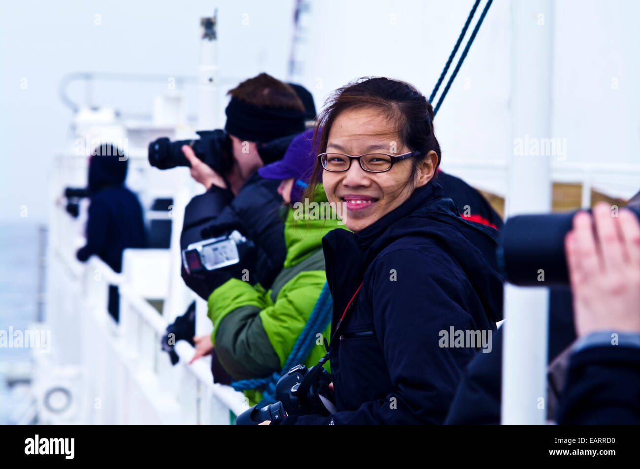 Un touriste excité sur le pont d'un navire de vent en direction de l'Antarctique. Banque D'Images