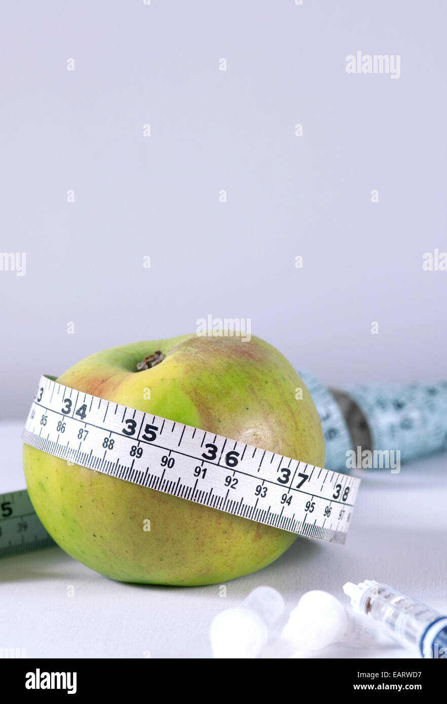 Image vie encore de Bramley Apple avec ruban de mesure et d'insuline flexpen Novo Novartis en premier plan Banque D'Images