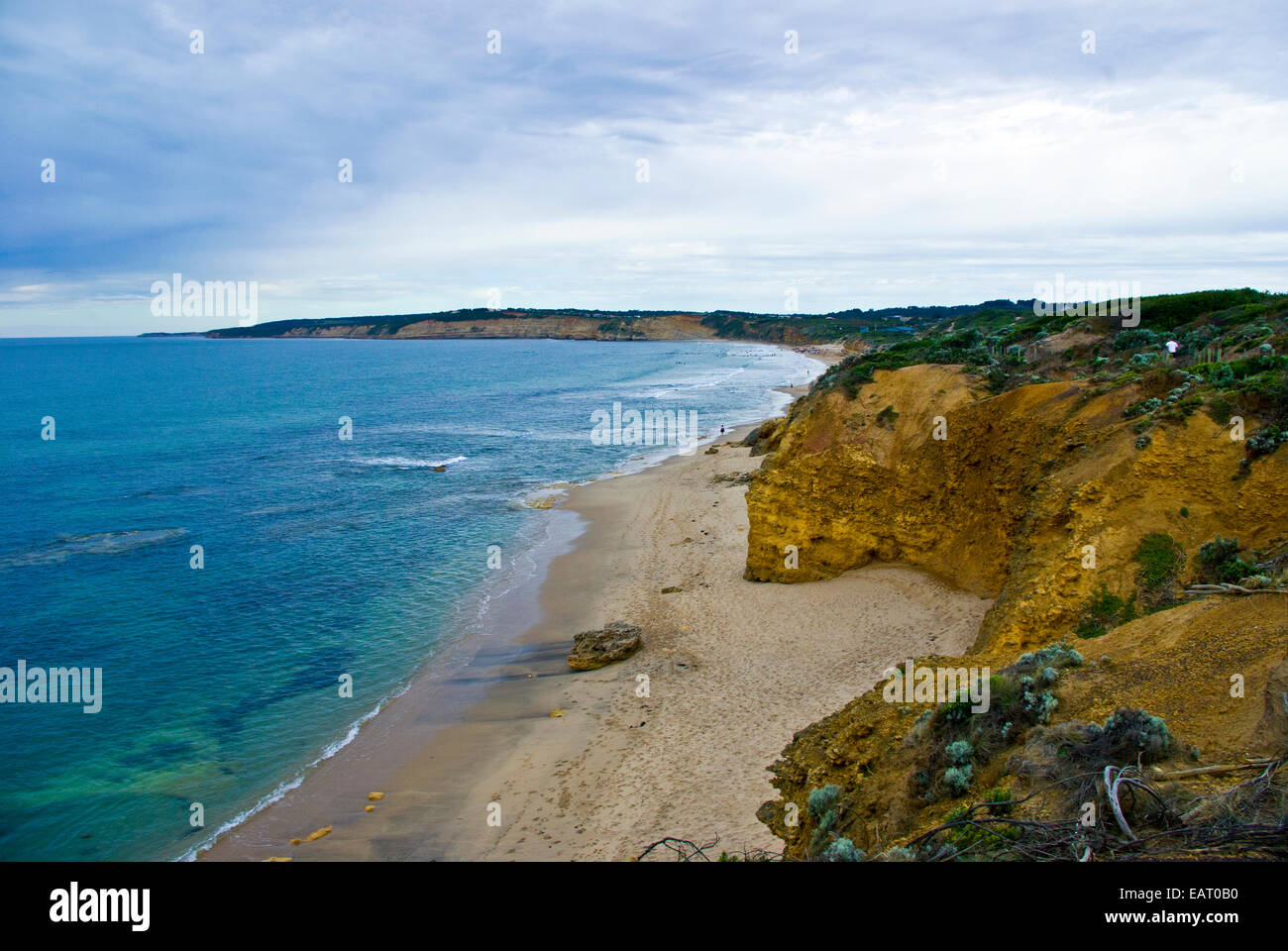 Les nuages gris sur une plage abritée sous une falaise de grès. Banque D'Images