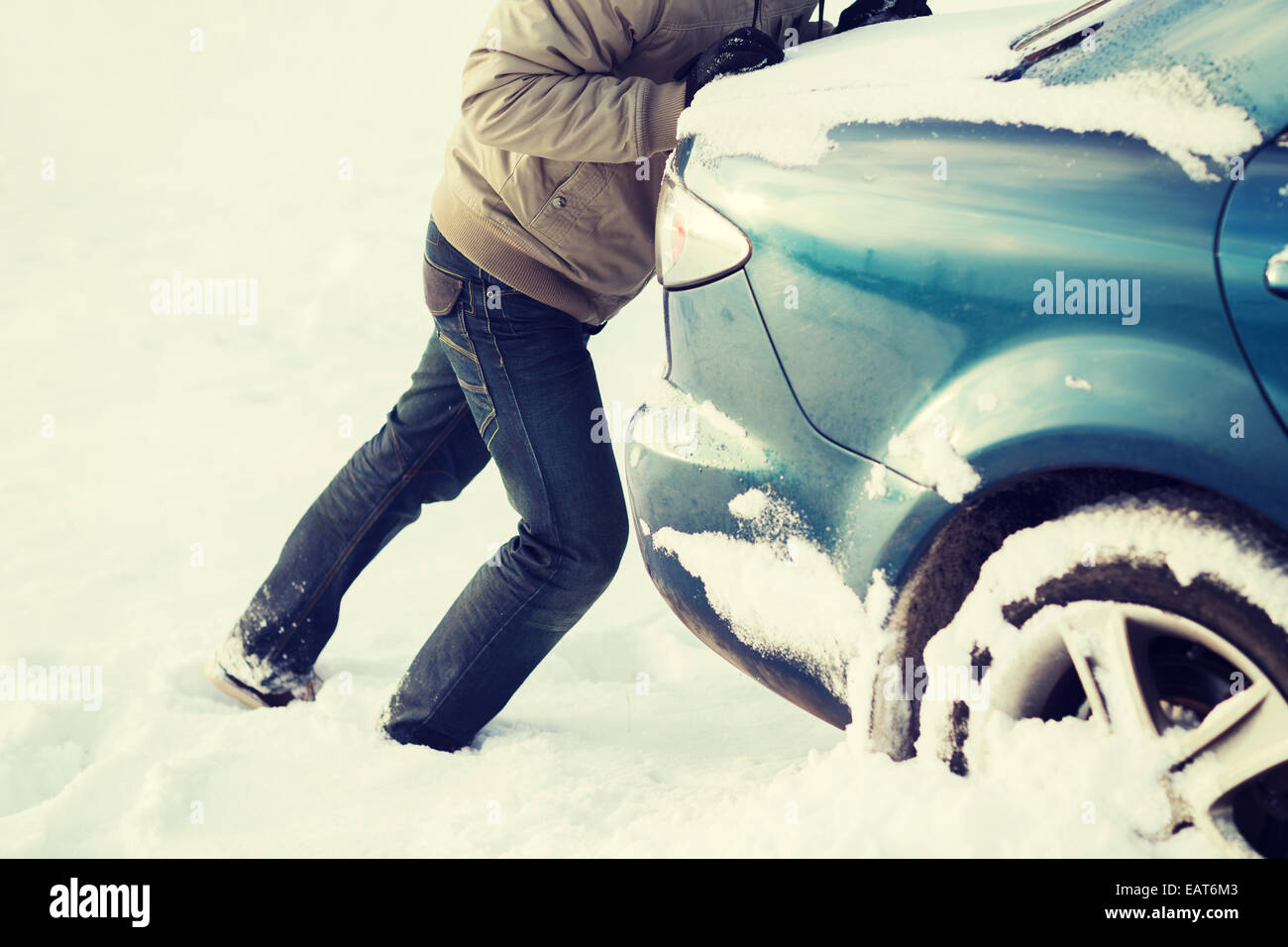 Libre de l'homme coincé dans la neige voiture poussant Banque D'Images