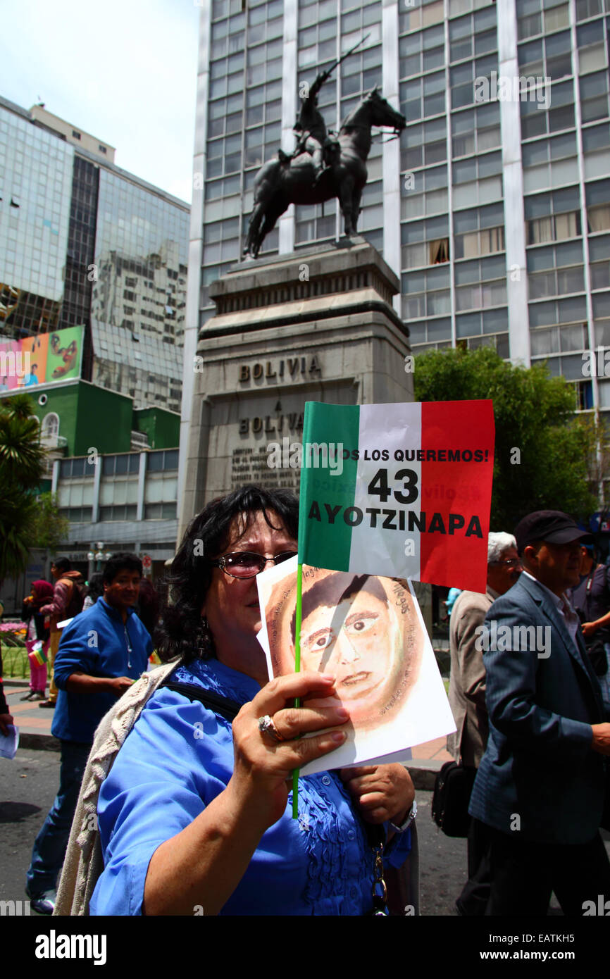 La Paz, Bolivie. 20 novembre, 2014. Les manifestants passent une statue de Simón Bolivar pendant une marche pour réclamer justice pour les 43 étudiants disparus au Mexique et protester contre le gouvernement mexicain pour son traitement de l'affaire et la corruption. Aujourd'hui a été désigné une journée mondiale d'action pour l'Ayotzinapa ; une grève nationale est prévue au Mexique et beaucoup de manifestations ont lieu dans le monde entier pour montrer son appui. Les élèves ont disparu après des affrontements avec la police dans la nuit du 26 septembre dans la ville d'Iguala. Brunker Crédit : James/Alamy Live News Banque D'Images