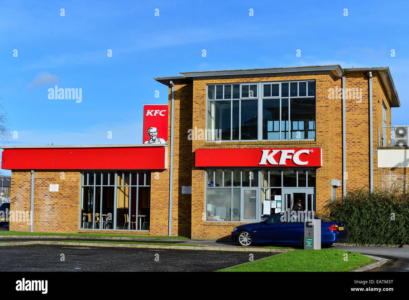 Stock Photo - KFC Kentucky Fried Chicken Drive Thru panneau rouge avec le Colonel Sanders sur route avec ciel bleu. Banque D'Images