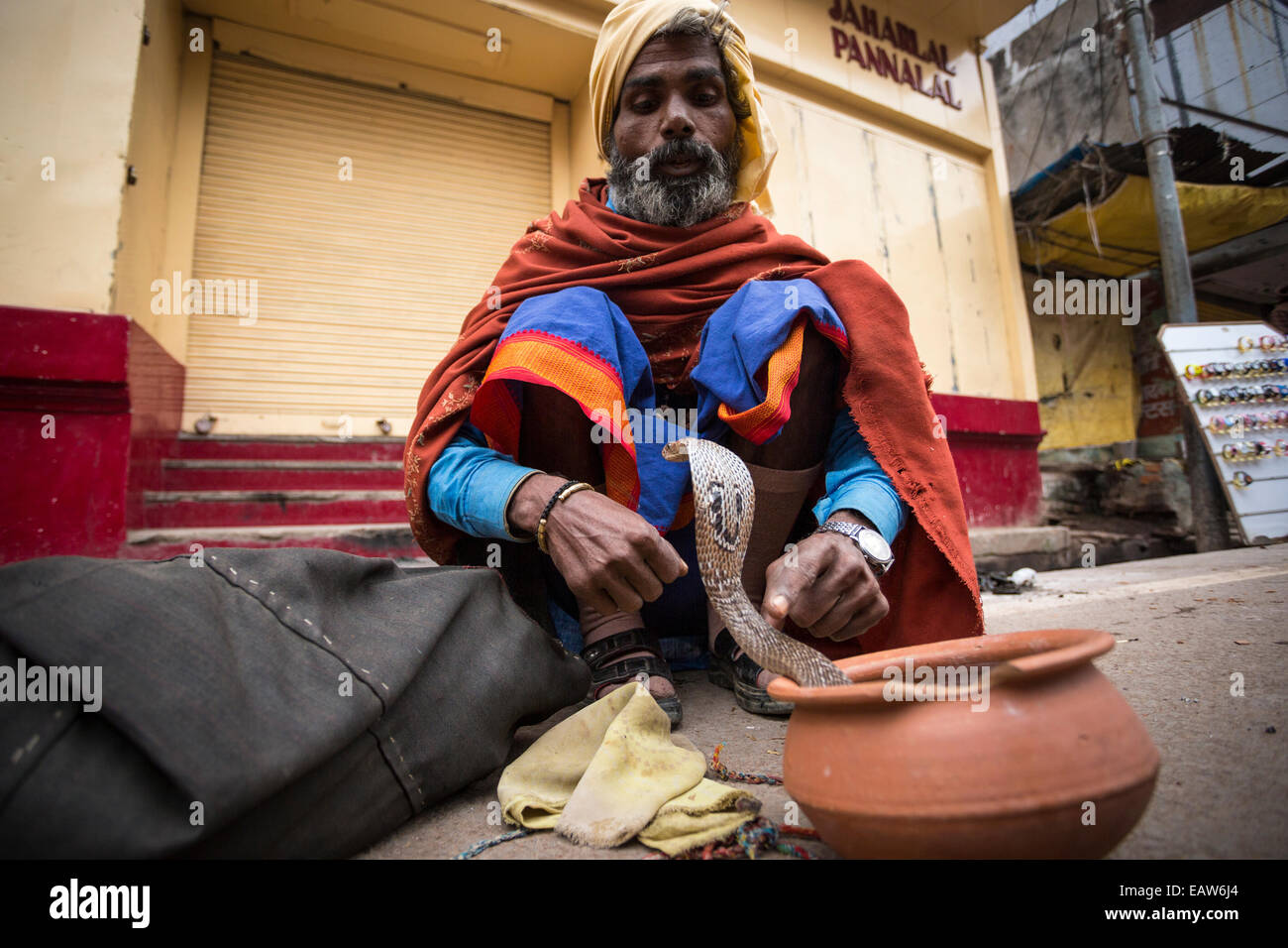 Un homme charms un serpent dans les rues de Varanasi en Inde. Banque D'Images