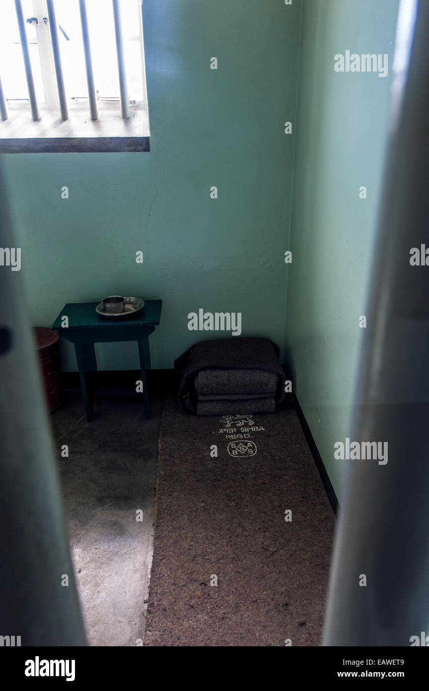 Une tasse, bol et lit de camp dans la cellule habitée par Nelson Mandela. Banque D'Images