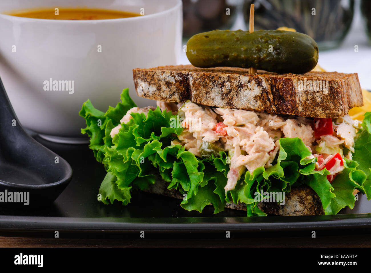 Sandwich à la salade de thon avec de la laitue sur le seigle toast avec soupe à la courge musquée, croustilles de pommes de terre, et un cornichon Banque D'Images