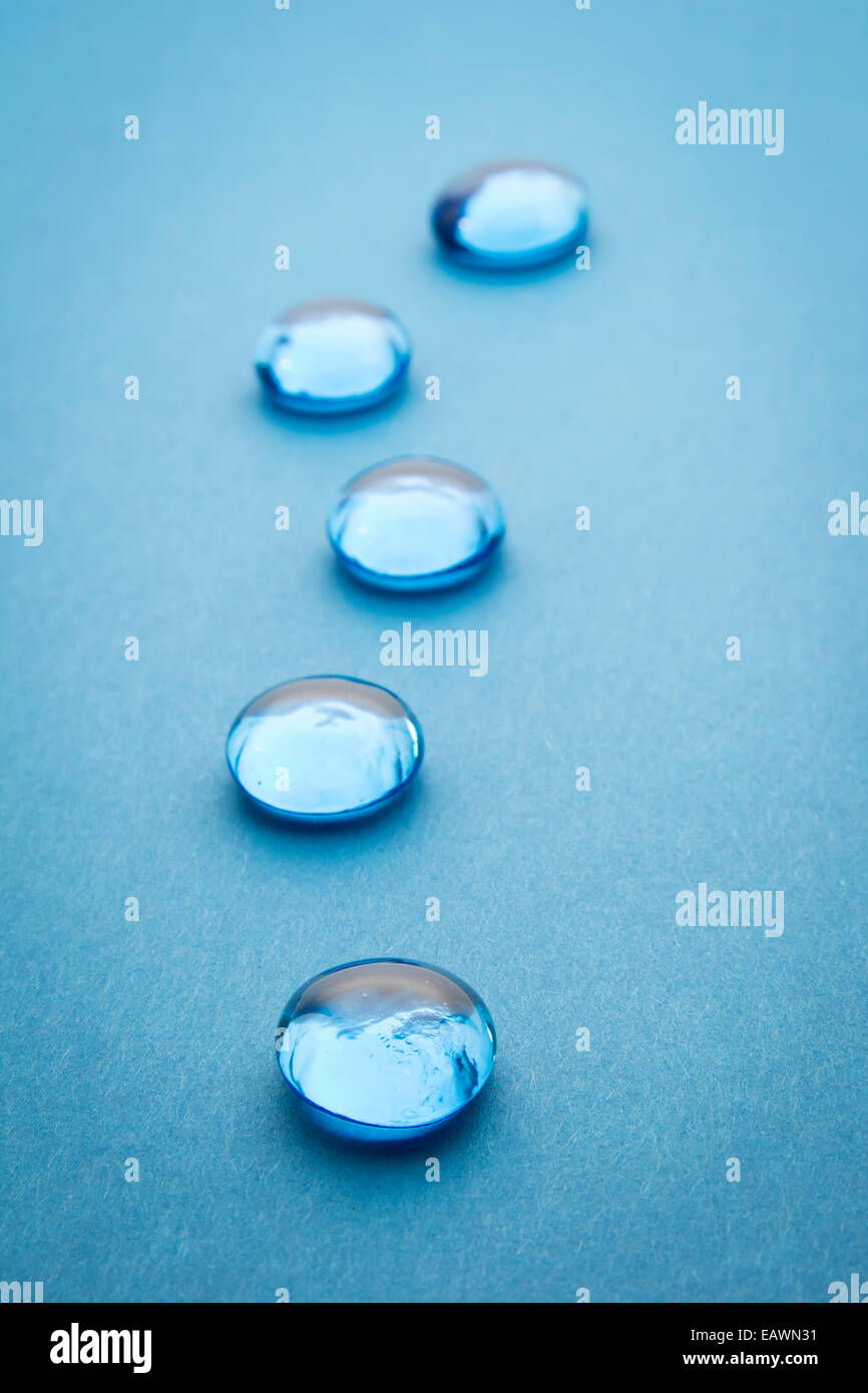 Perles de verre sur fond bleu, selective focus Banque D'Images