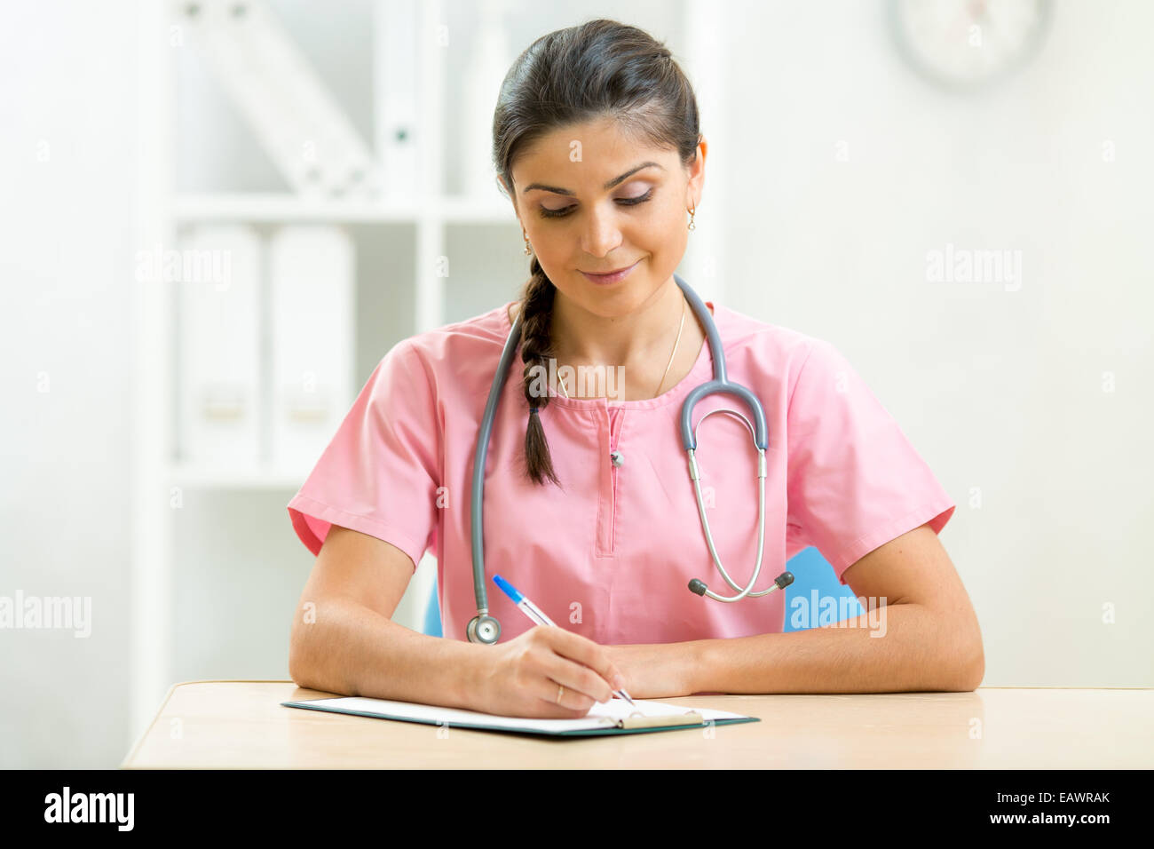 Female doctor sitting at desk in doctor's room Banque D'Images