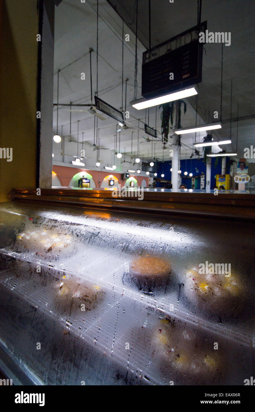 Par temps humide, de la condensation se forme sur la vitre glacée d'un présentoir de gâteaux dans une boulangerie. Banque D'Images