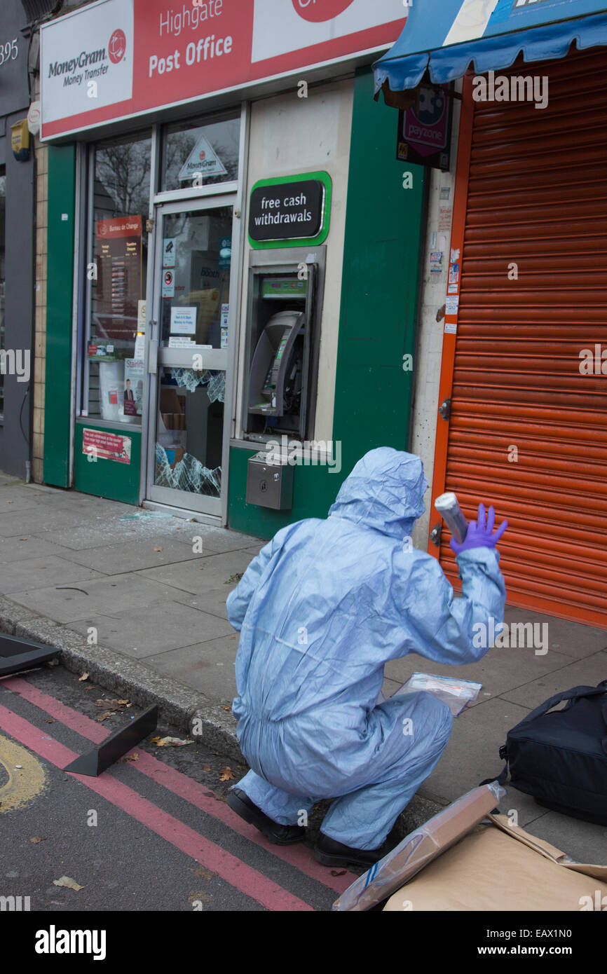 Londres, Royaume-Uni. 21 novembre 2014. Avec un bureau de poste de Highgate shattered porte avant et un sac ATM. Le bureau de poste de Highgate, au nord de Londres, a été cambriolée pendant la nuit et les voleurs ont tenté de faire sauter l'ATM qui fait face à la route d'Archway occupé. Une scène de crime est l'examen de la scène. Photo : Nick Savage/Alamy Live News Banque D'Images