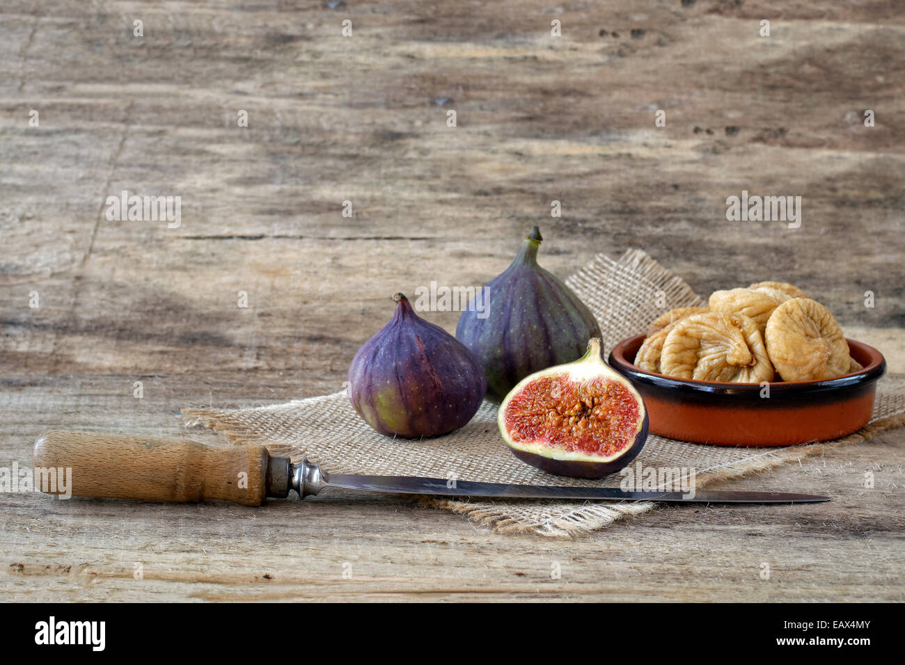 Couper les figues sèches et fraîches avec couteau sur toile et bois Banque D'Images