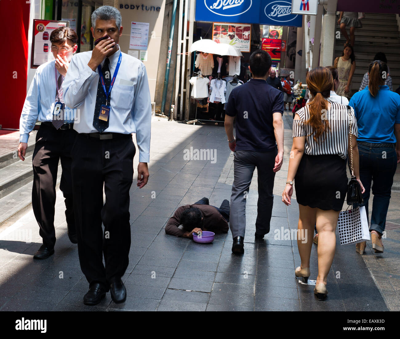 Mendiant handicapé sur Silom Road, Bangkok, Thaïlande, les gens de la classe moyenne par pied. Banque D'Images