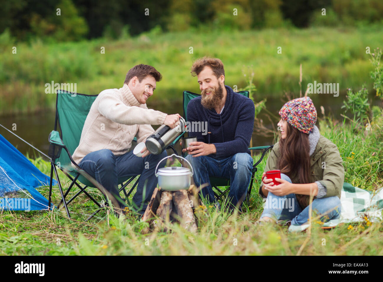 Groupe de touristes souriants la cuisson des aliments dans camping Banque D'Images