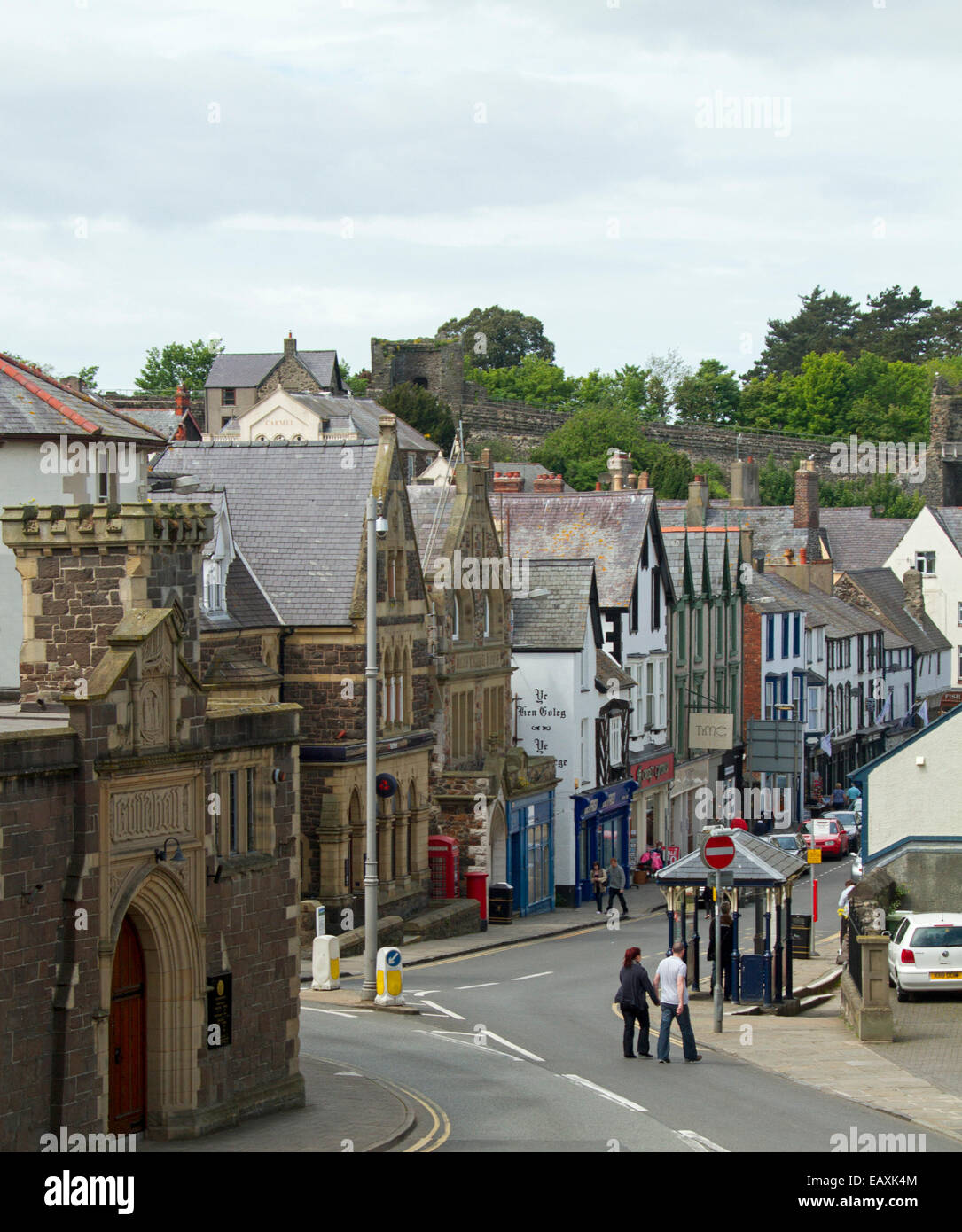 Rue principale du village gallois, Conwy, bordée de bâtiments historiques et avec des gens crossing road , au Pays de Galles Banque D'Images