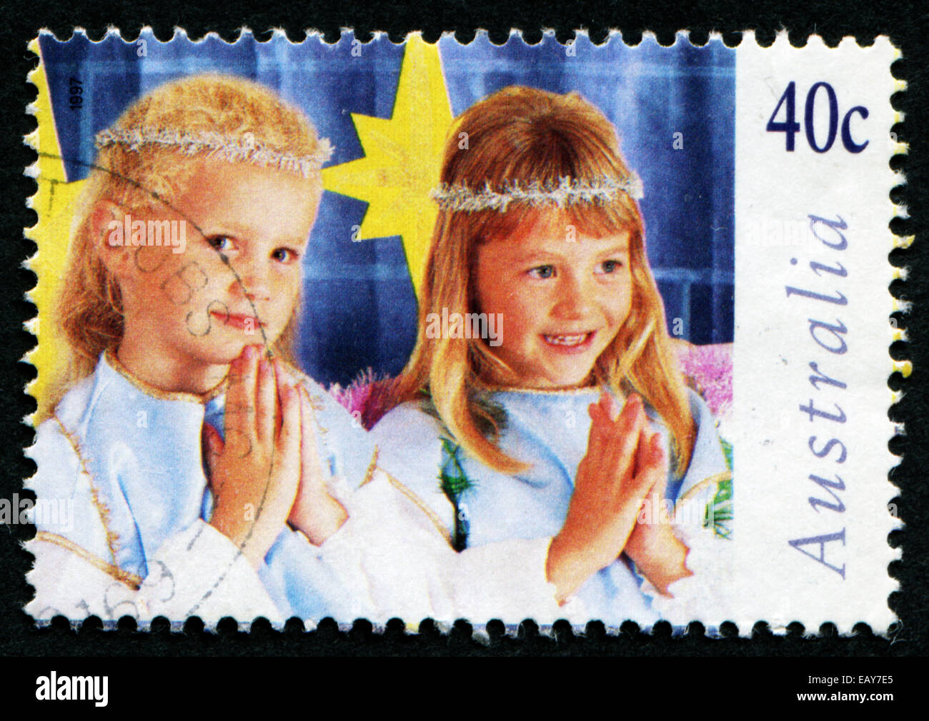 L'AUSTRALIE - circa 1997 : timbre-poste imprimé en Australie avec l'image de deux jeunes filles en costume de prier. Banque D'Images