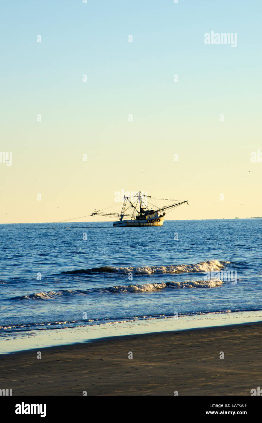 Bateau de crevettes au coucher du soleil : un bateau crevette travaille l'océan Atlantique au large de l'île d'Hilton Head juste avant le coucher du soleil. Banque D'Images