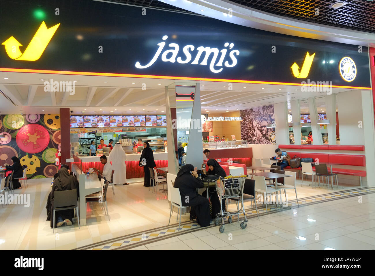 Avoir un en-cas à ce fast food avant de monter à bord de l'avion à la salle d'embarquement à l'Aéroport International de Bahreïn, Bahreïn, au Moyen-Orient. Bahreïn a une population de plus de 55  % des immigrants et a eu des élections générales en ce jour. Banque D'Images