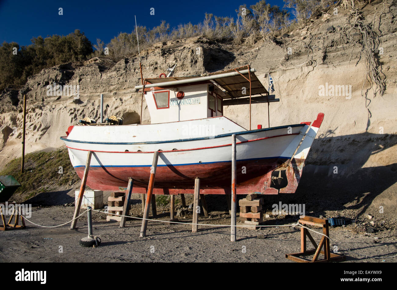 Un bateau de pêche en cours de maintenance dans la région de Vlichada, Santorin, Grèce. Banque D'Images