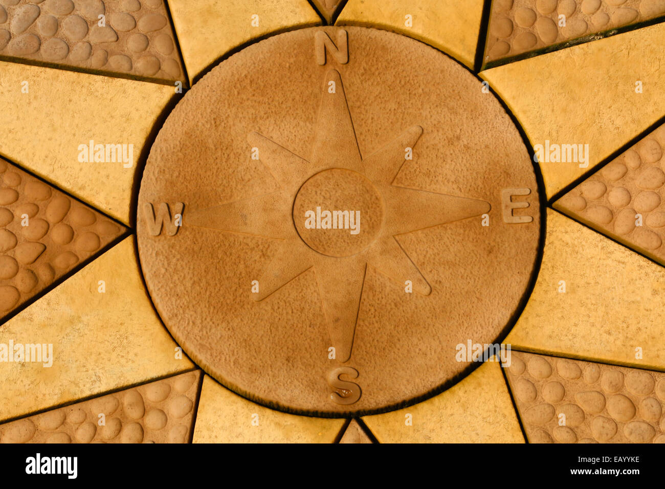 Rose des vents en pierre situé dans une étoile. Dalles de couleur dorée. Banque D'Images