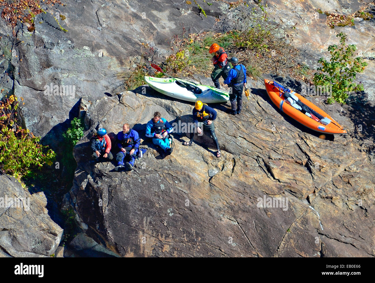 TALLULAH FALLS, GA, USA - NOVEMBRE, 2- Un groupe de kayakistes en appui sur un rocher et regarder les autres après une course dans les rapides. Banque D'Images