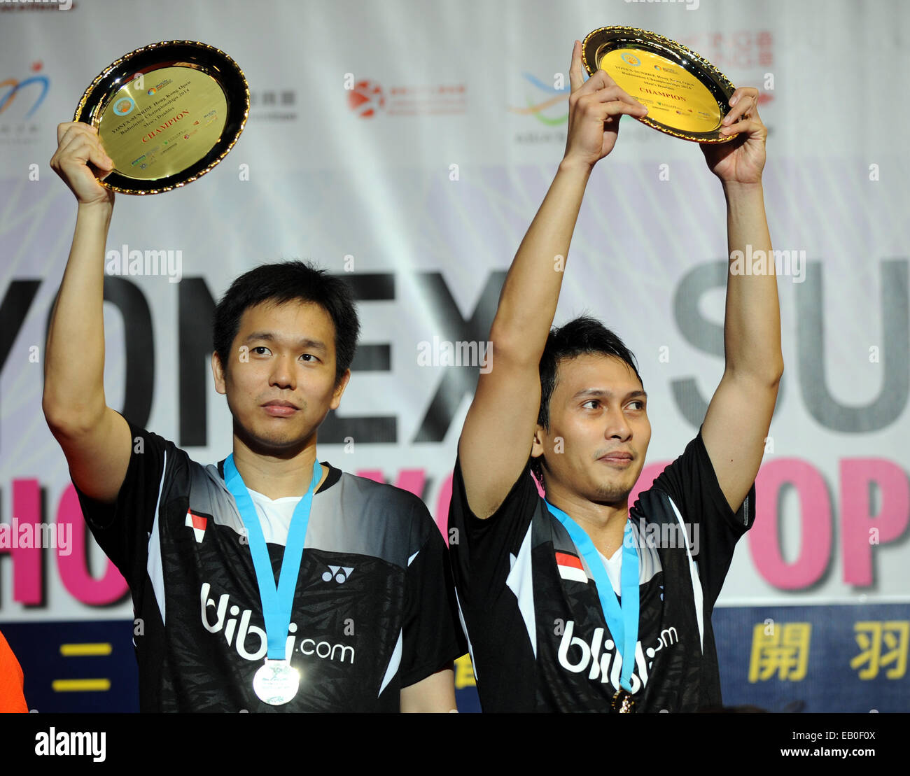 Hong Kong. 23 Nov, 2014. Hendra Setiawan(L) et Mohammad Ahsan d'Indonésie montrent leurs trophées lors de la cérémonie pour l'hommes double final du Yonex-Sunrise Hong Kong Open tournoi de badminton à Hong Kong Coliseum de Hong Kong, le 23 novembre 2014. Hendra Setiawan et Ahsan Mohammad réclamé le titre en battant Liu Xiaolong et Qiu Zihan de Chine avec 2-1 (21-16, 17-21, 21-15). © Lo Fai Ping/Xinhua/Alamy Live News Banque D'Images