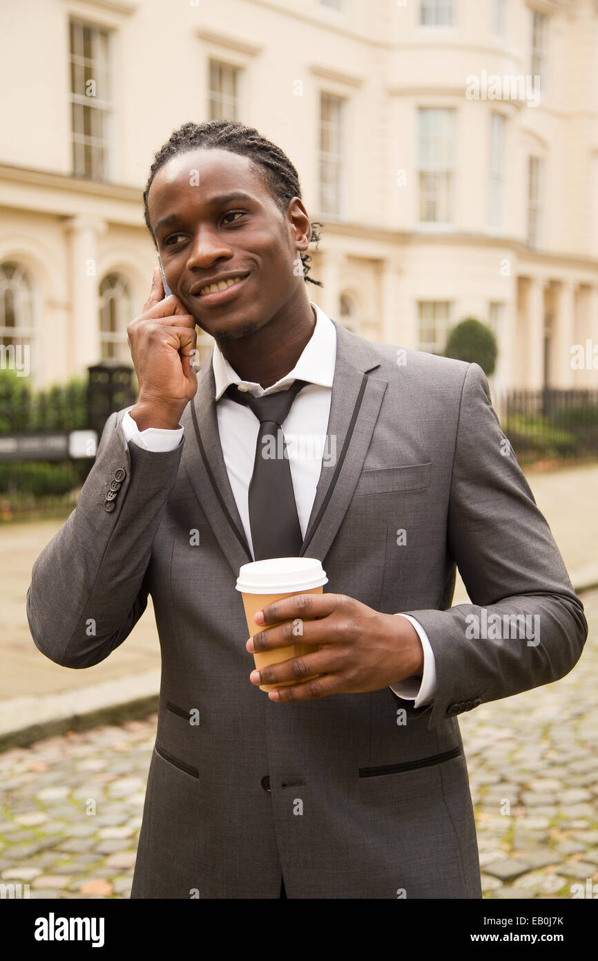 L'homme d'affaires avec un café sur le téléphone Banque D'Images
