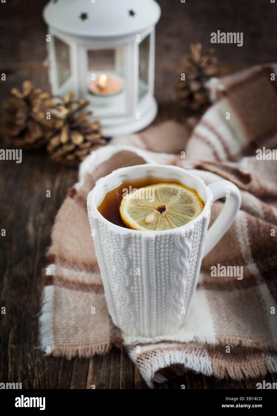 Tasse de thé chaud avec du citron et un foulard sur la table en bois. Banque D'Images