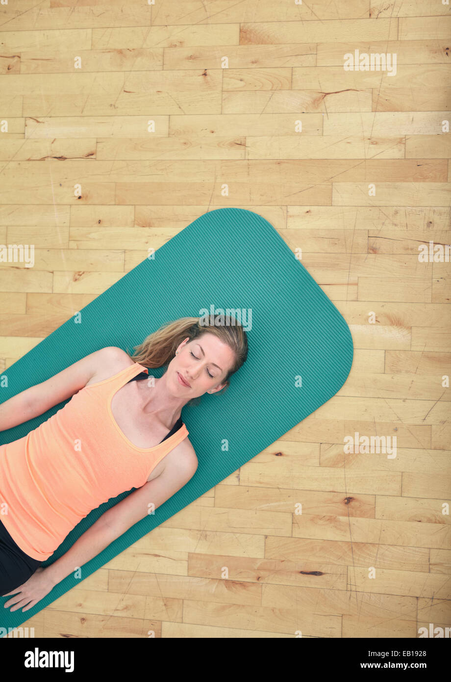 Top View of woman relaxing on yoga mat avec copie espace. Femme de remise en forme situé sur tapis d'exercice à la salle de sport. Banque D'Images